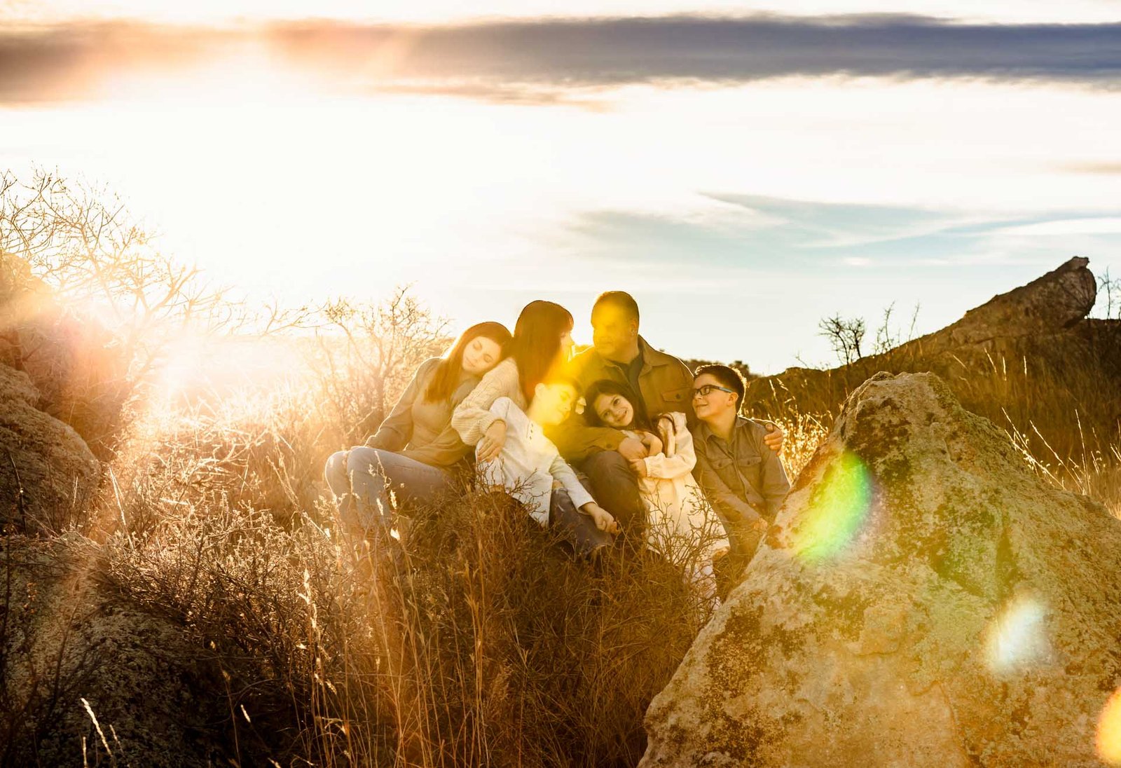 Family of 6 sitting together in a field at Golden Hour in Denver Family Photography